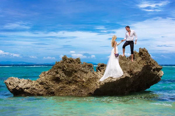 Lyckliga bruden och brudgummen att ha kul på en tropisk strand under p — Stockfoto