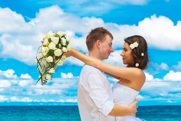 Happy bride and groom having fun on a tropical beach — Stock Photo, Image