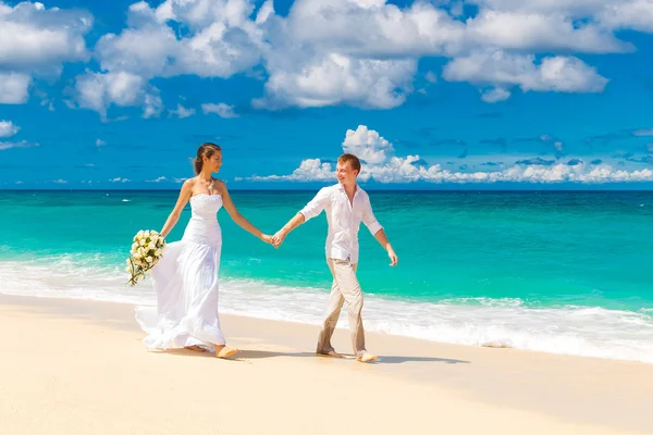 Noiva feliz e noivo se divertindo em uma praia tropical — Fotografia de Stock