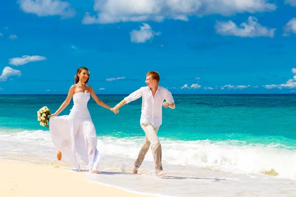 Novia feliz y novio divirtiéndose en una playa tropical — Foto de Stock