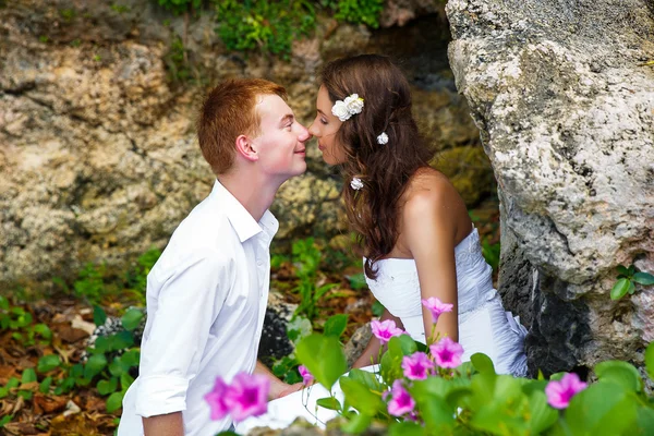 Happy bride and groom having fun on a tropical beach — Stock Photo, Image