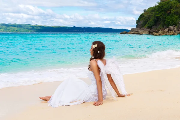 Bela noiva jovem com asas de anjo na costa do mar. Tropica — Fotografia de Stock