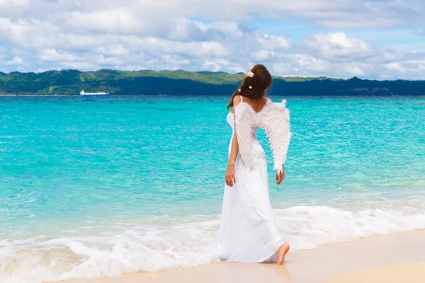 Mooie jonge bruid met engel vleugels aan de zeekust. Tropica — Stockfoto