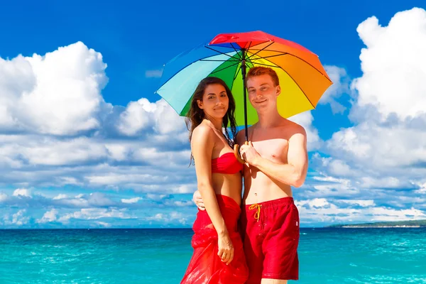 Joven feliz amante pareja divirtiéndose en la playa tropical con — Foto de Stock