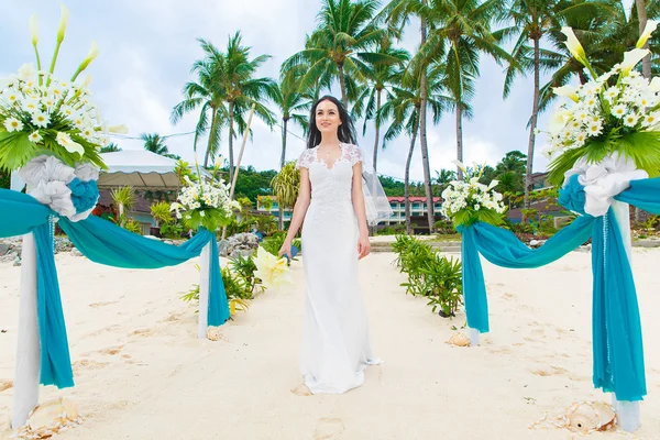 Matrimonio in spiaggia. La sposa sta andando sulla spiaggia di sabbia a t — Foto Stock