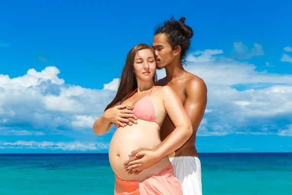 आनंदी आणि युवा गर्भवती कपल येत मजा पर एक उष्णकटिबंधीय बीच . — स्टॉक फोटो, इमेज