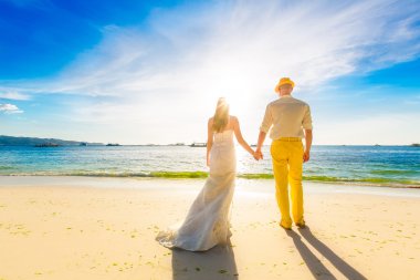 Gelin ve damat backg günbatımında ile tropikal bir plajda