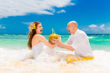 Happy bride and groom drink coconut water and having fun on a tr clipart