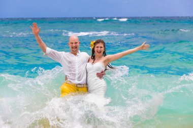 Mutlu gelin ve damat bir tropikal beac dalgalar eğleniyor