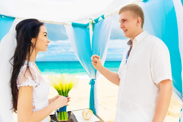 Groom giving an engagement ring to his bride under the arch deco — Stock Photo, Image