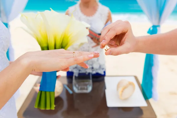 Groom giving an engagement ring to his bride under the arch deco — Stock Photo, Image