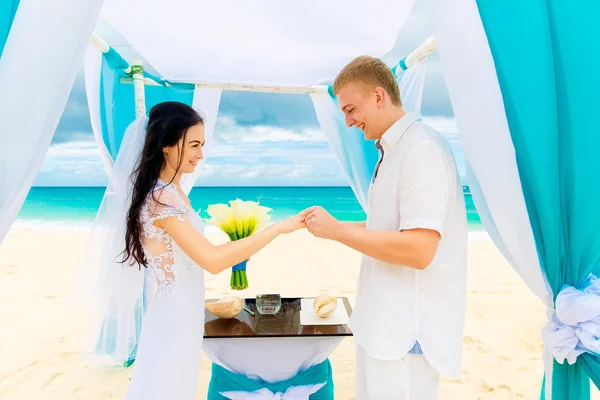 Bruidegom een verlovingsring te geven aan zijn bruid onder de boog deco — Stockfoto