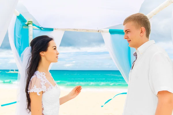 Bride giving an engagement ring to her groom under the arch deco — Stock Photo, Image