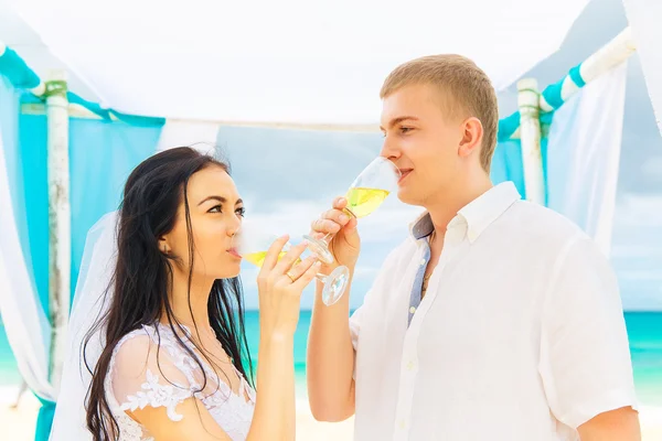 De ceremonie van het huwelijk op een tropisch strand in blauw. Gelukkige bruidegom en br — Stockfoto