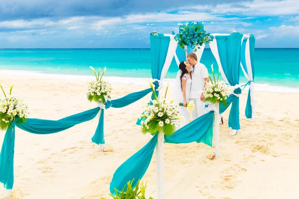 De ceremonie van het huwelijk op een tropisch strand in blauw. Gelukkige bruidegom en br — Stockfoto