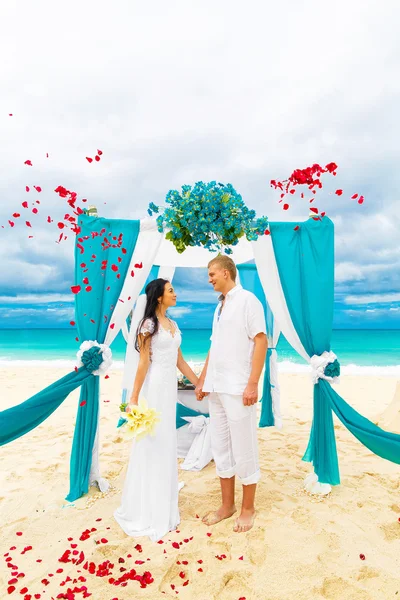 Ceremonia de boda en una playa tropical en azul. novio feliz y br —  Fotos de Stock