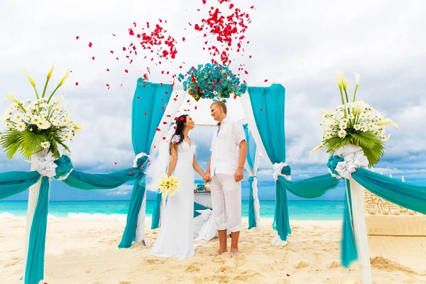 De ceremonie van het huwelijk op een tropisch strand in blauw. Gelukkige bruidegom en br — Stockfoto