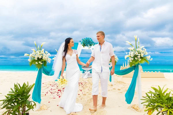 Ceremonia de boda en una playa tropical en azul. novio feliz y br — Foto de Stock