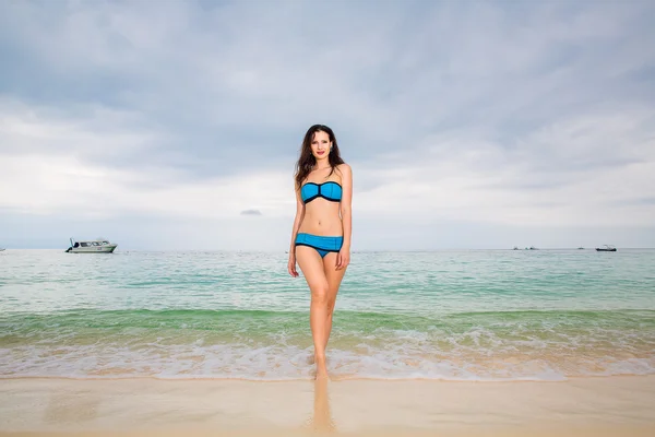 Mooie jonge vrouw in bikini op een tropisch strand — Stockfoto