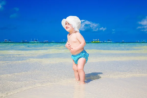Een klein kind plezier op een tropisch strand. — Stockfoto