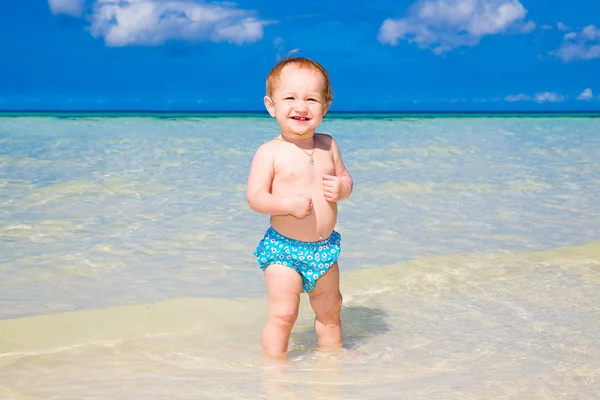 Ett litet barn ha roligt på en tropisk strand. — Stockfoto