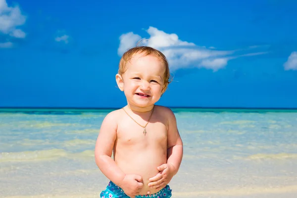 Een klein kind plezier op een tropisch strand. — Stockfoto