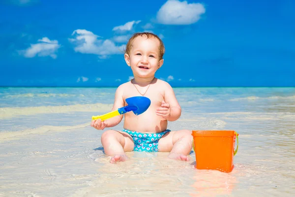 Un niño divirtiéndose en una playa tropical. Con vacaciones de verano —  Fotos de Stock