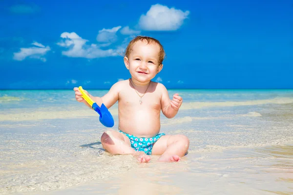 Ein kleines Kind, das sich an einem tropischen Strand amüsiert. Sommerferienprogramm — Stockfoto
