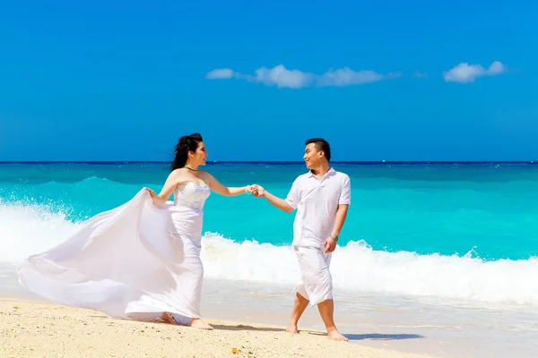 Novia y novio asiáticos en una playa tropical. Boda y luna de miel — Foto de Stock