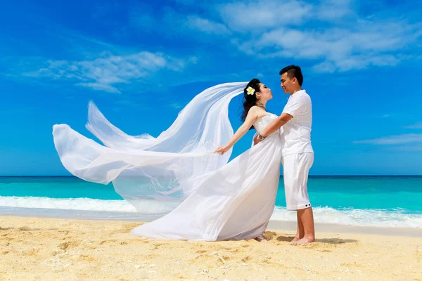 Asya gelin ve damat bir tropikal plaj. Düğün ve balayı