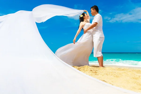 Novia y novio asiáticos en una playa tropical. Boda y luna de miel — Foto de Stock