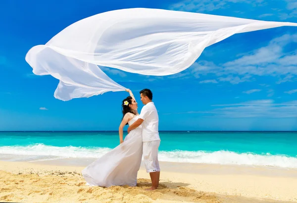 Asya gelin ve damat bir tropikal plaj. Düğün ve balayı