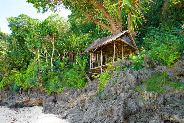 Mooi meisje in een bamboe hut in een tropische jungle. — Stockfoto