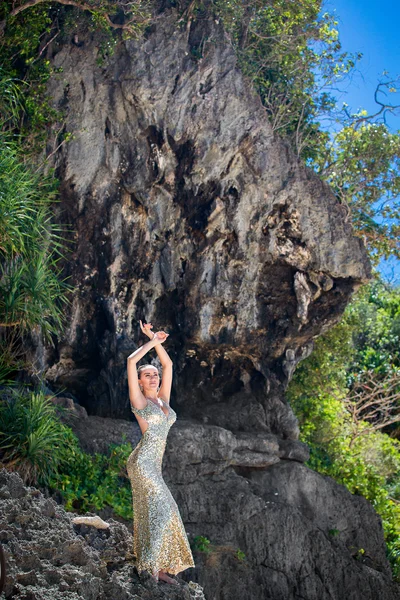 Giovane bella ragazza in abito d'oro sulla spiaggia di un tropicale è — Foto Stock