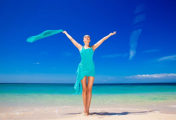 Mooi meisje in blauwe jurk op het strand van een tropische is — Stockfoto