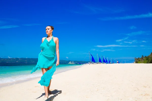 Je krásná mladá dívka v modrých šatech na pláži tropickém — Stock fotografie