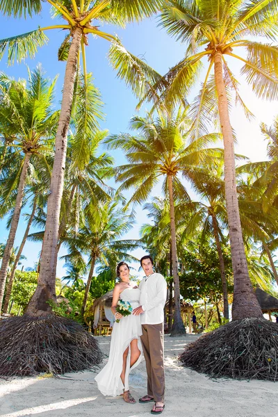 Novia feliz y novio divirtiéndose en una playa tropical bajo el p —  Fotos de Stock