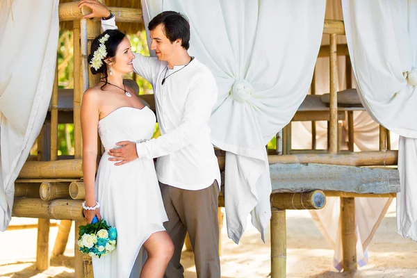 Gelukkige bruid en bruidegom plezier op een tropisch strand onder de p — Stockfoto
