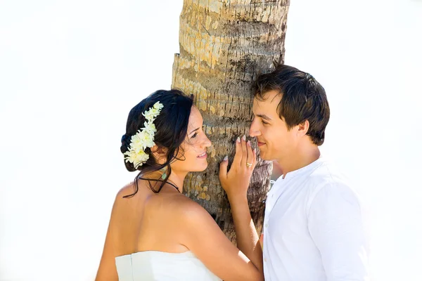 Happy bride and groom having fun on a tropical beach under the p — Stock Photo, Image