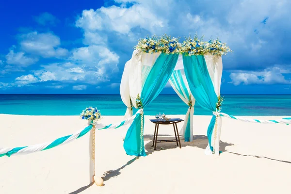 Matrimonio in spiaggia. Arco da sposa decorato con fiori su tr — Foto Stock