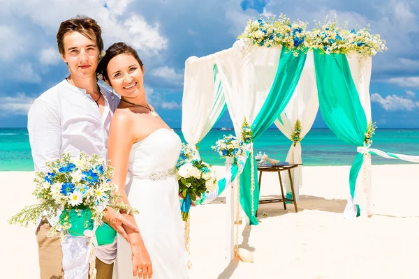 Bröllop på en tropisk strand i blått. Happy brudgummen och br — Stockfoto