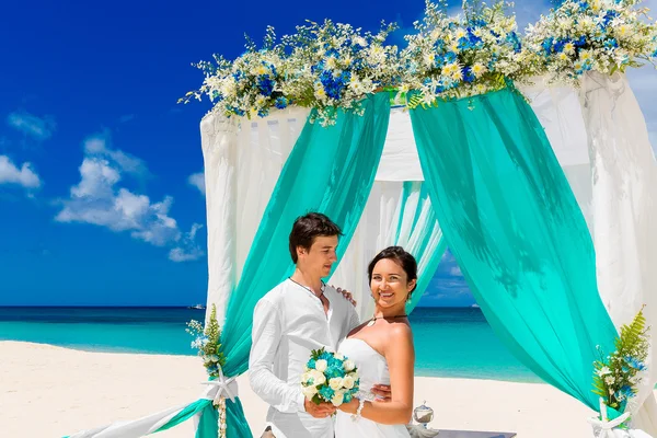 Bröllop på en tropisk strand i blått. Happy brudgummen och br — Stockfoto