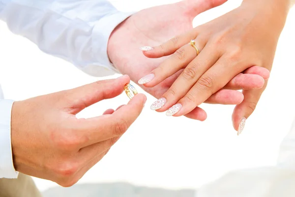 Groom giving an engagement ring to his bride under the arch deco — Stock Photo, Image