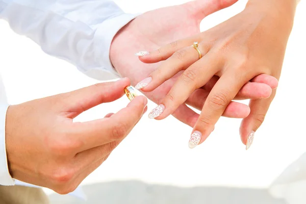 Brudgummen ger en förlovningsring till sin brud under hålfoten deco — Stockfoto
