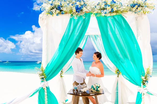 Bruid een verlovingsring te geven aan haar bruidegom onder de boog deco — Stockfoto