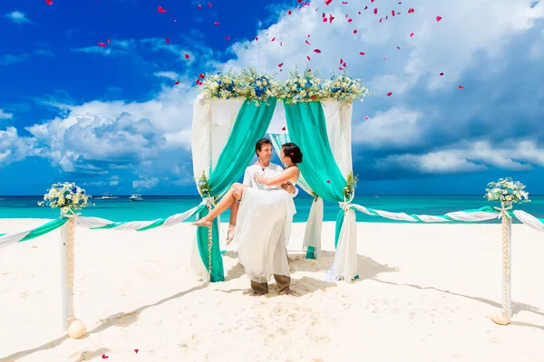 De ceremonie van het huwelijk op een tropisch strand in blauw. Gelukkige bruidegom en br — Stockfoto