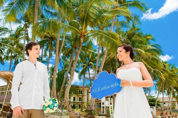 Noiva feliz e noivo se divertindo em uma praia tropical sob o p — Fotografia de Stock