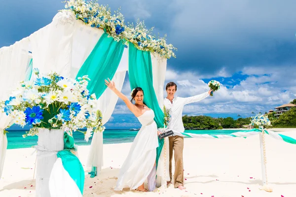 Mavi bir tropik sahilde düğün töreni. Mutlu damat ve br