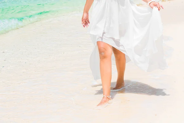 Bella giovane sposa in un abito da sposa bianco a piedi su un trop — Foto Stock