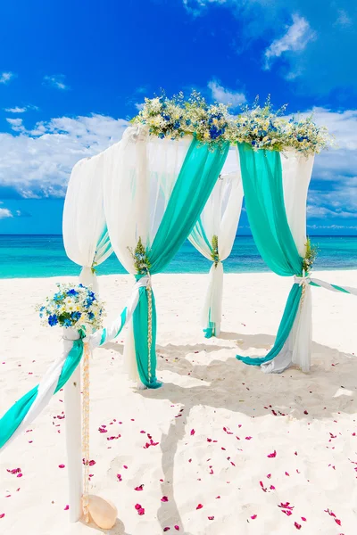 Bruiloft op het strand. Huwelijksboog versierd met bloemen op tr — Stockfoto